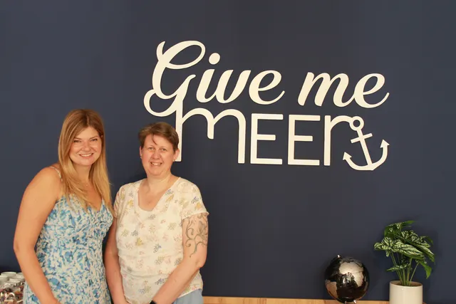 Unser Team vor der Give me Meer Wand im Büro Ilmenau