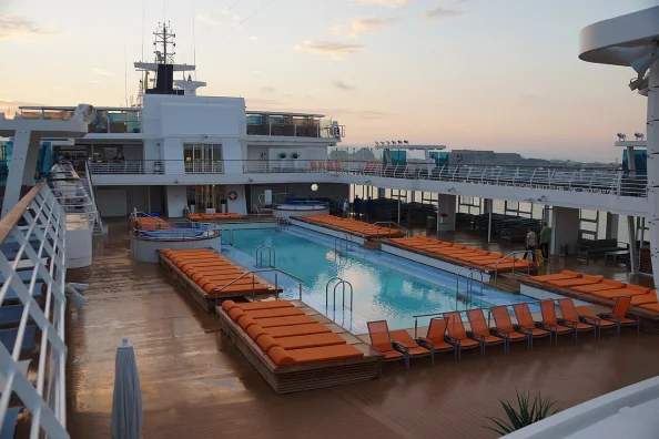 Pooldeck der Mein Schiff 3 mit Außenpool und orangefarbenen Liegen