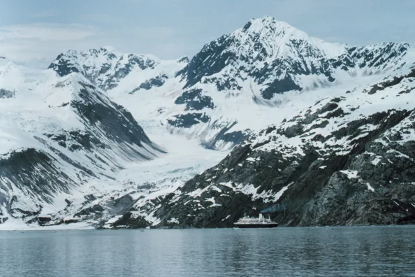 Kreuzfahrtschiff umgeben von schneebedeckten Bergen in der Glacier Bay, Alaska